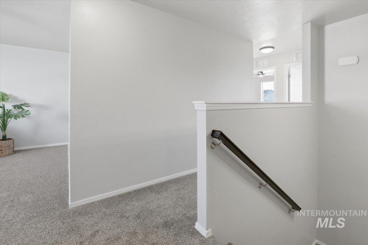 Staircase with carpet floors and baseboards