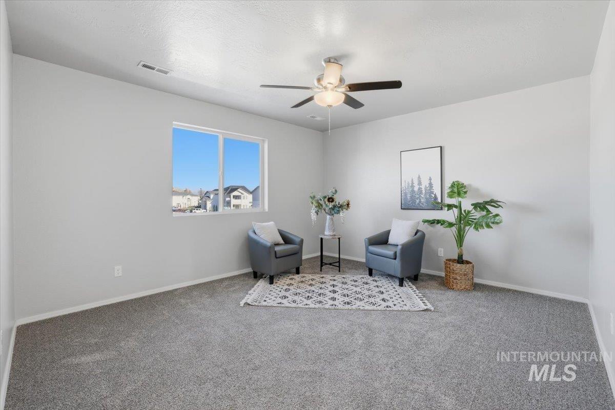 Sitting room with carpet floors, ceiling fan, and a textured ceiling