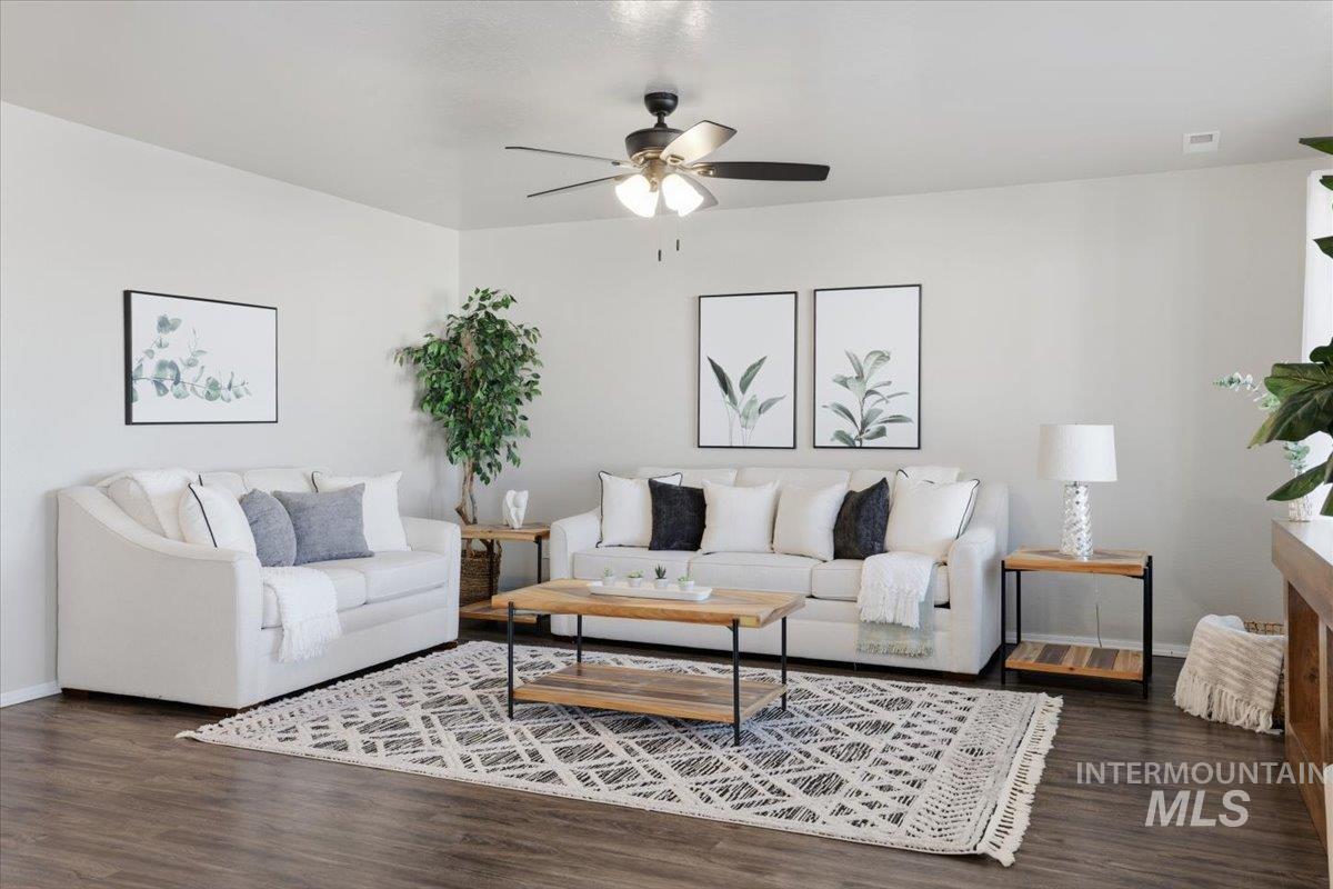 Living room featuring dark wood-type flooring and ceiling fan