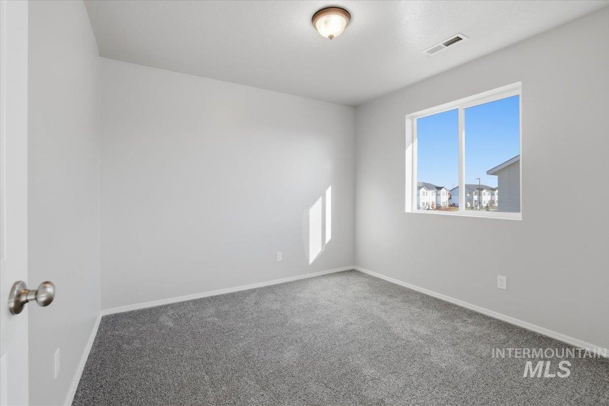 Carpeted empty room with baseboards