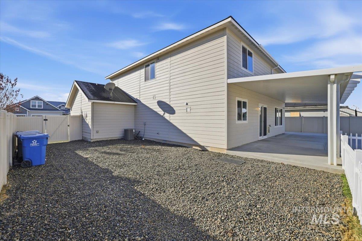 View of side of property featuring a fenced backyard, a patio, and a gate