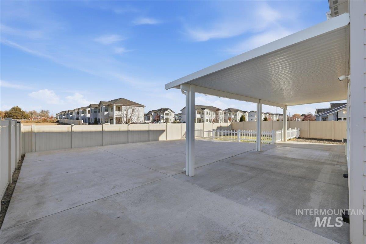 Fenced backyard with a residential view and a patio area