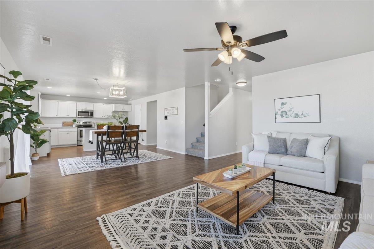 Living area featuring stairway, dark wood finished floors, recessed lighting, and a ceiling fan
