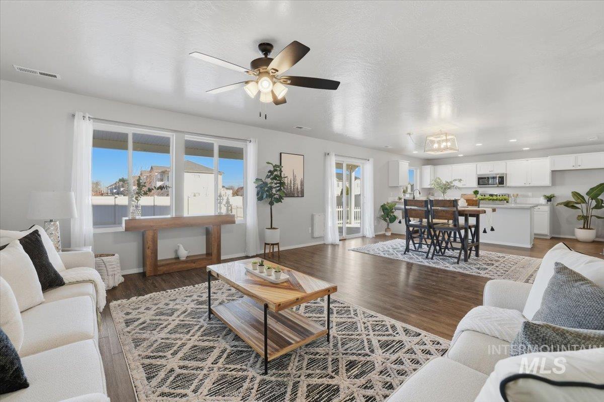 Living area featuring dark wood-style flooring and a ceiling fan
