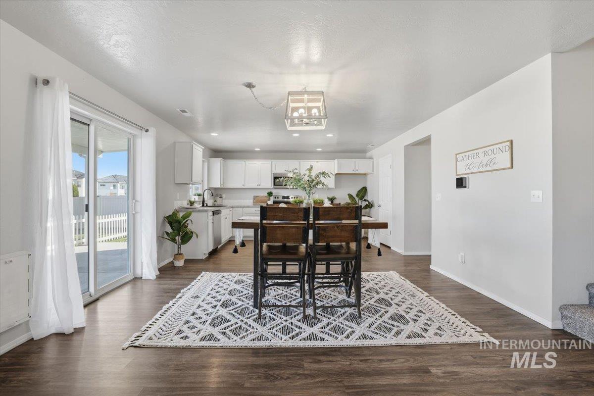 Dining room with dark wood-style flooring, recessed lighting, and a textured ceiling