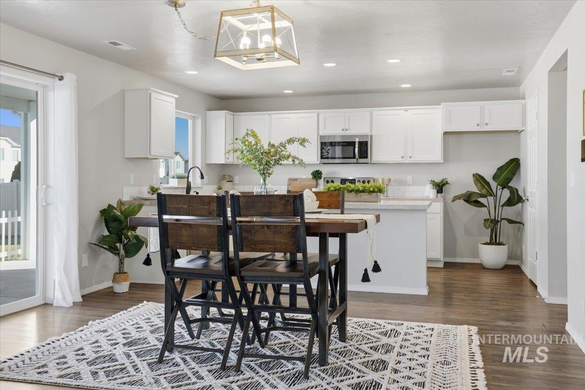 Dining space featuring dark wood finished floors, recessed lighting, and a chandelier