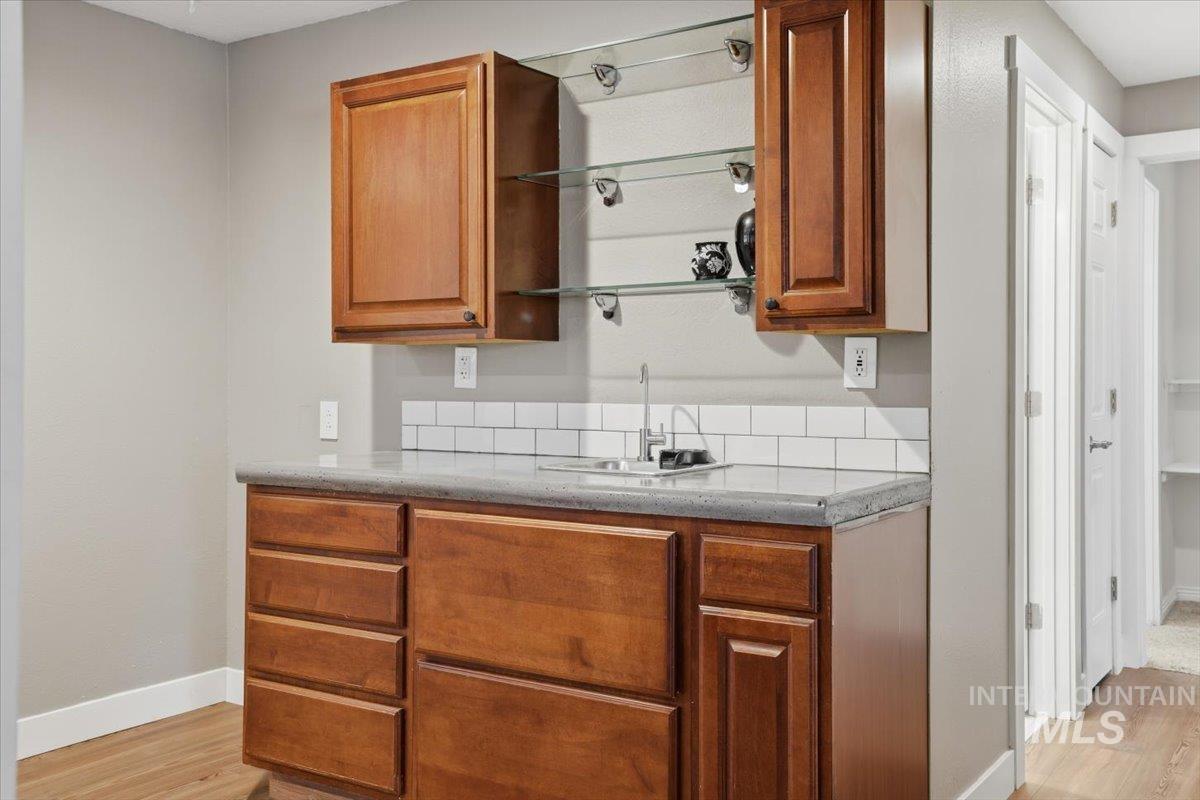 Kitchen featuring light stone counters, brown cabinets, and light wood-style floors
