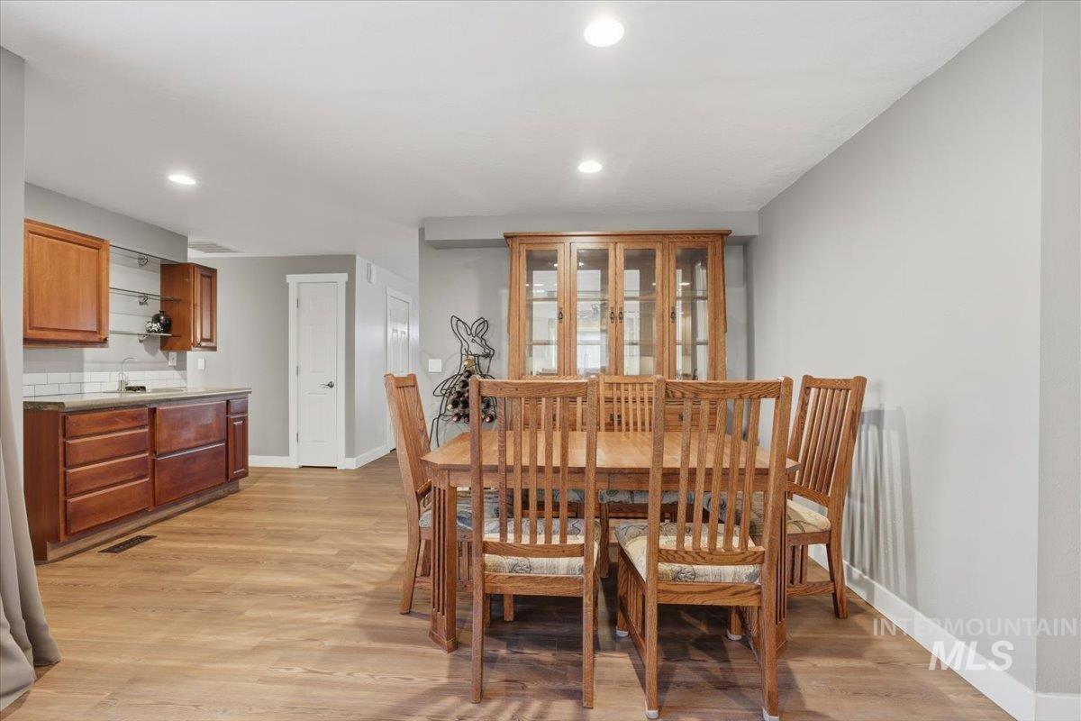 Dining space with light wood-style floors and recessed lighting