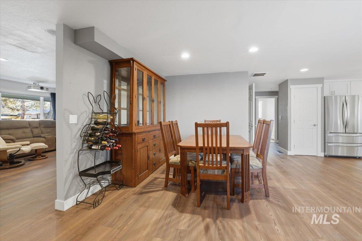 Dining area with light wood-style flooring and recessed lighting