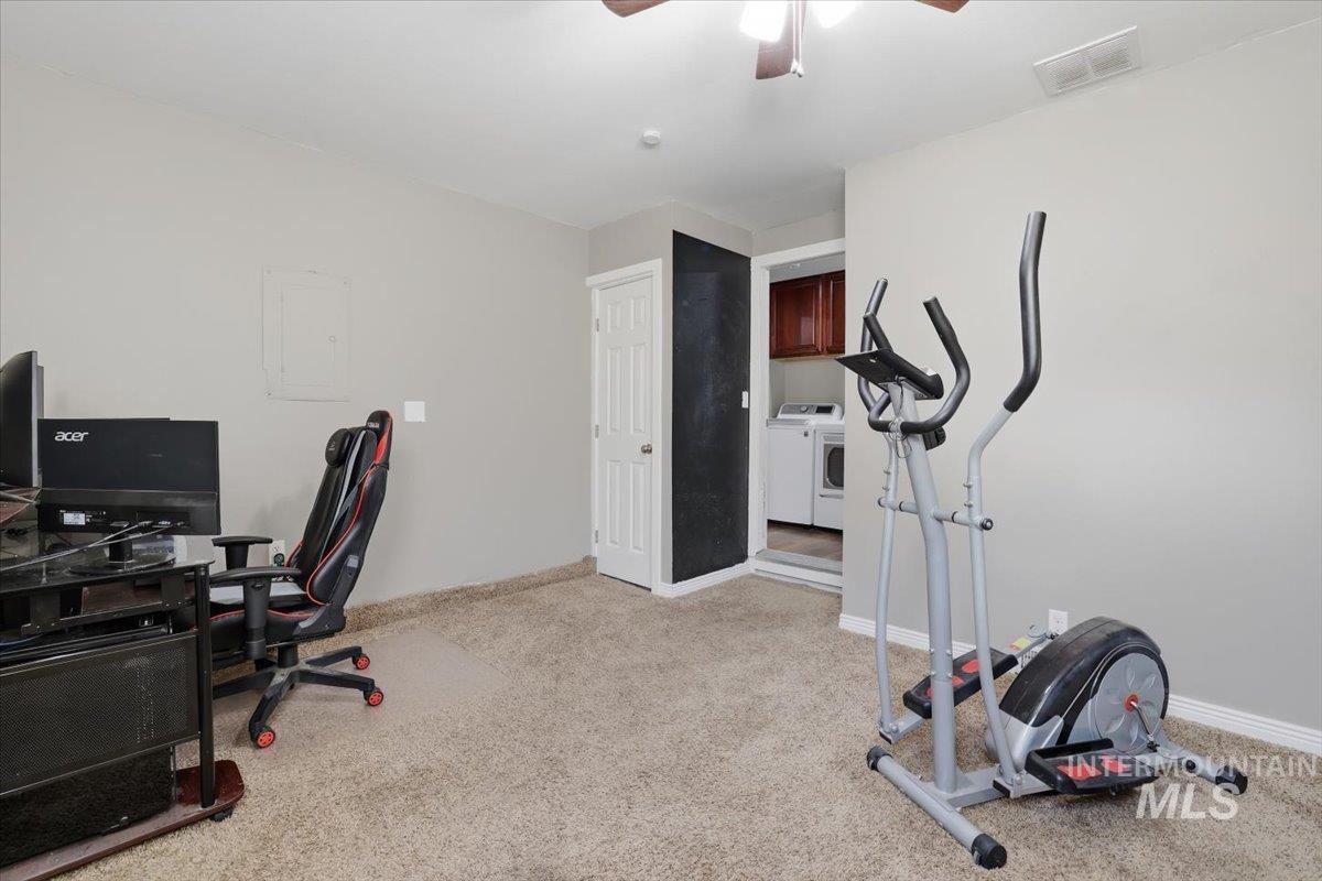 Office featuring light carpet, a ceiling fan, and washing machine and clothes dryer