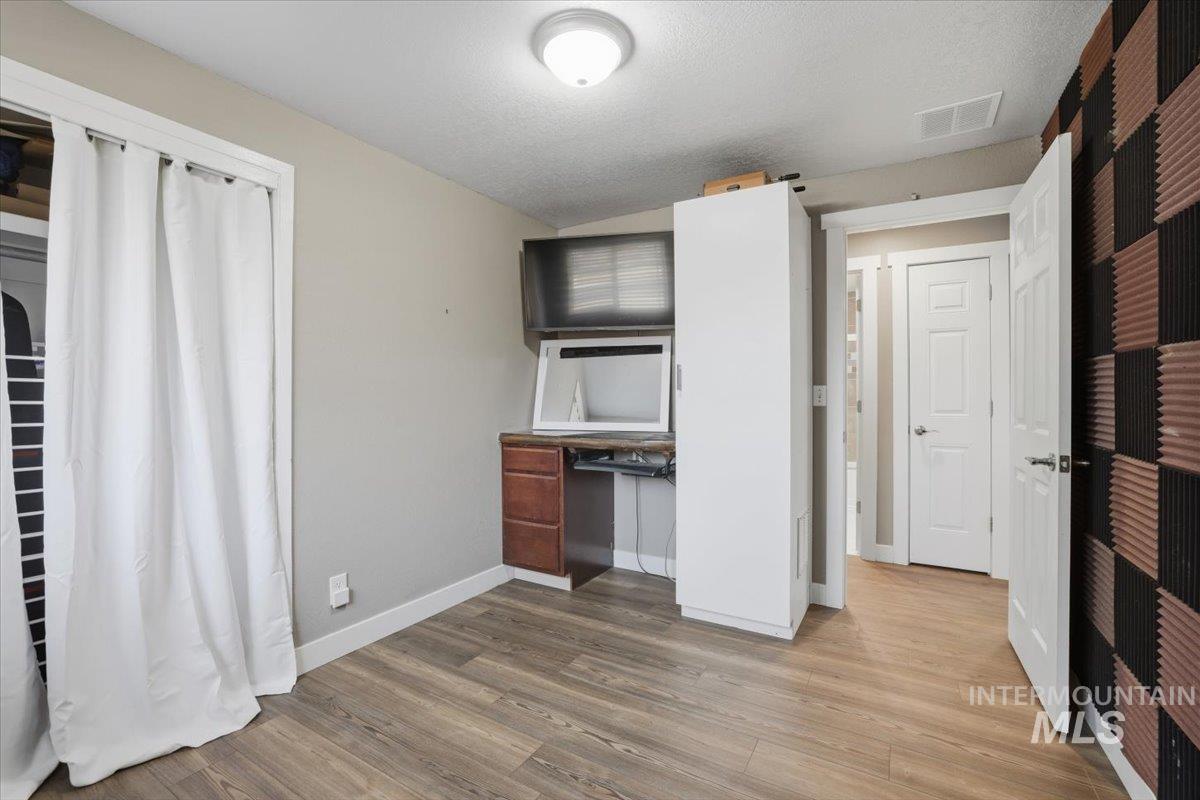Kitchen featuring a textured ceiling, light wood-style flooring, and built in desk