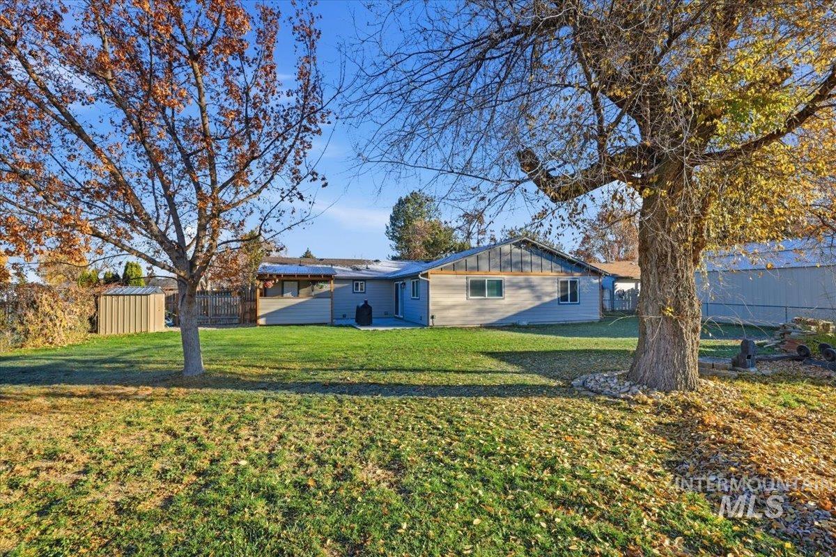 Rear view of house featuring board and batten siding and a patio