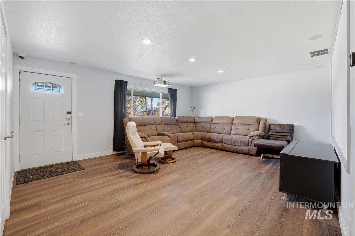 Living room featuring wood finished floors, recessed lighting, and a textured ceiling