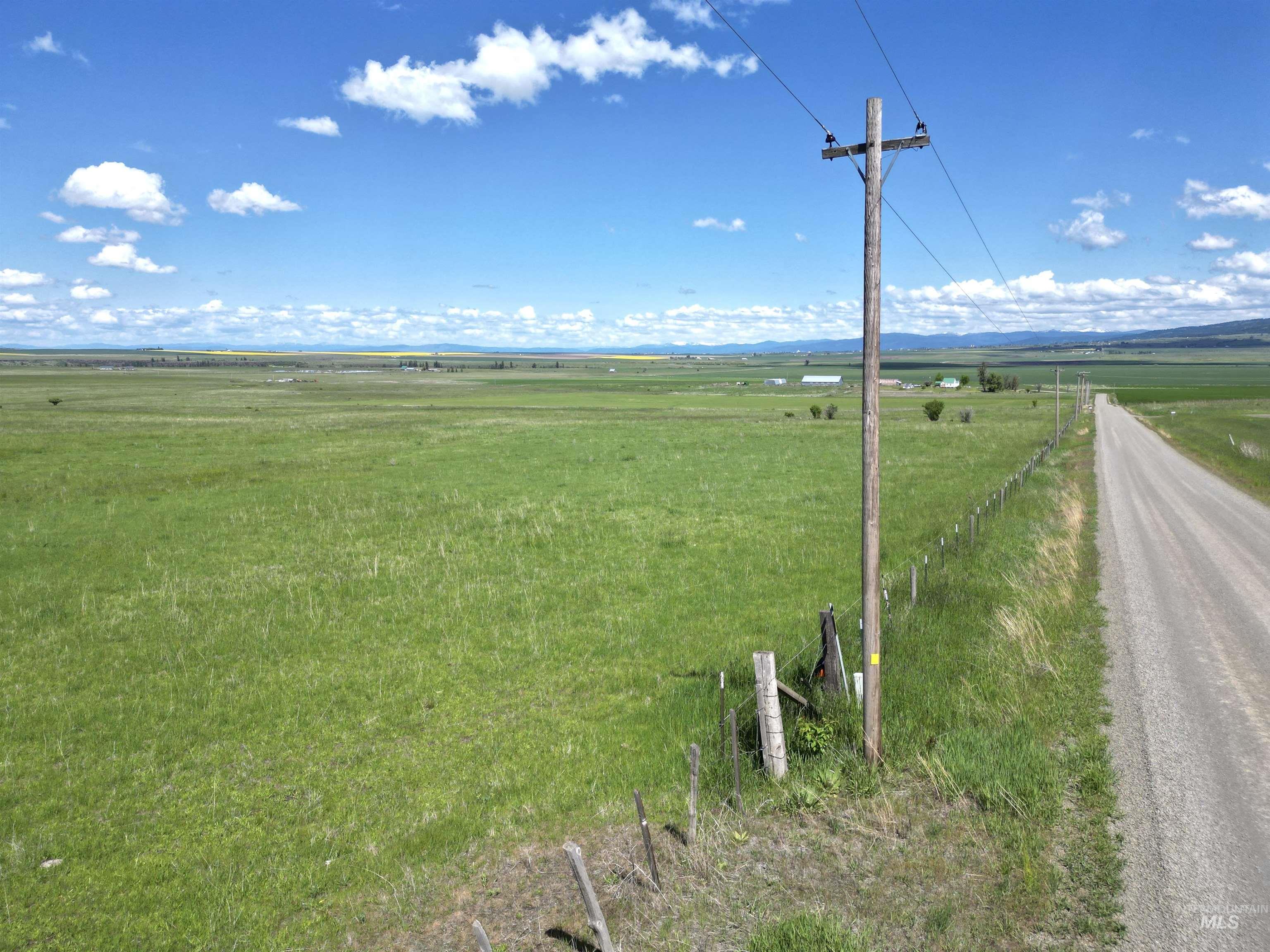 View of dirt / gravel road with a view of rural / pastoral area and a mountain view