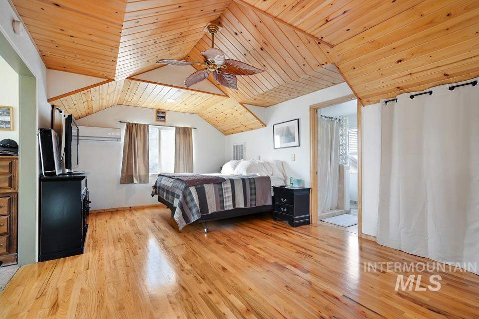 Bedroom with wooden ceiling, a ceiling fan, and light wood finished floors
