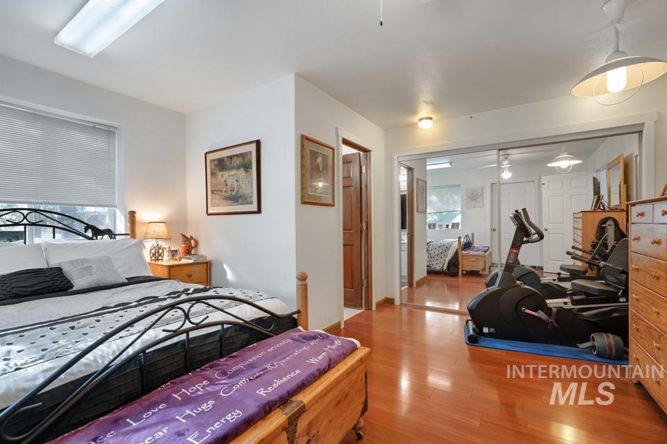 Bedroom featuring wood finished floors, a closet, and multiple windows