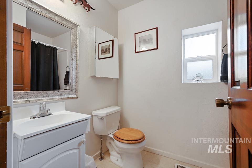 Bathroom featuring a shower with curtain, vanity, and light tile patterned floors