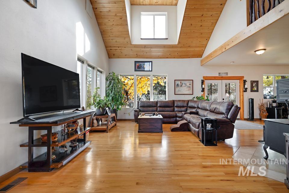 Living area with high vaulted ceiling, wood ceiling, and light wood finished floors