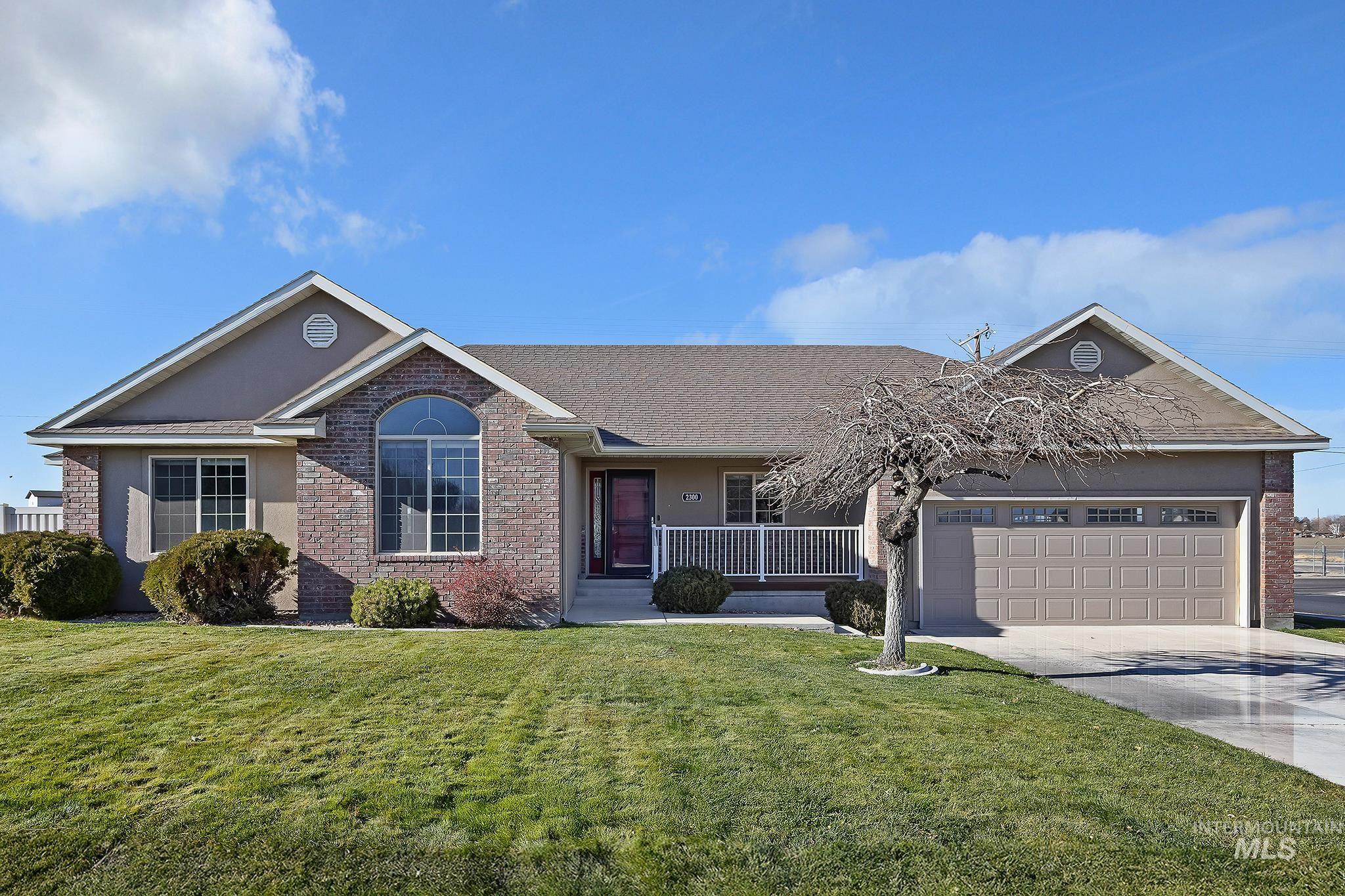 Ranch-style home featuring covered porch, concrete driveway, a front yard, a garage, and stucco siding