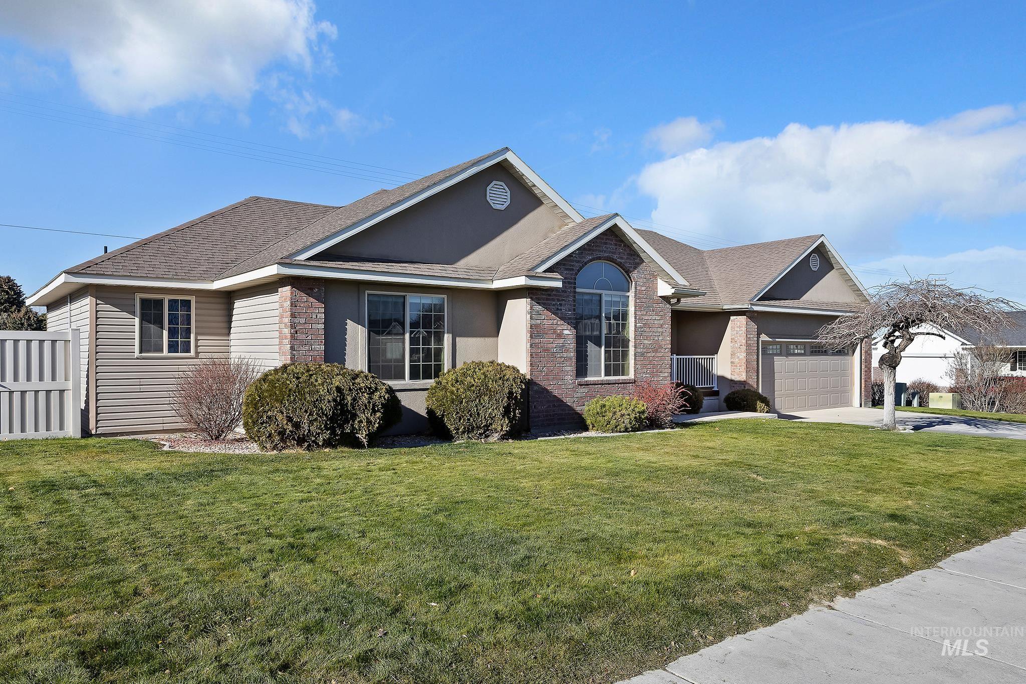 View of front of home featuring a shingled roof, brick siding, driveway, an attached garage, and stucco siding
