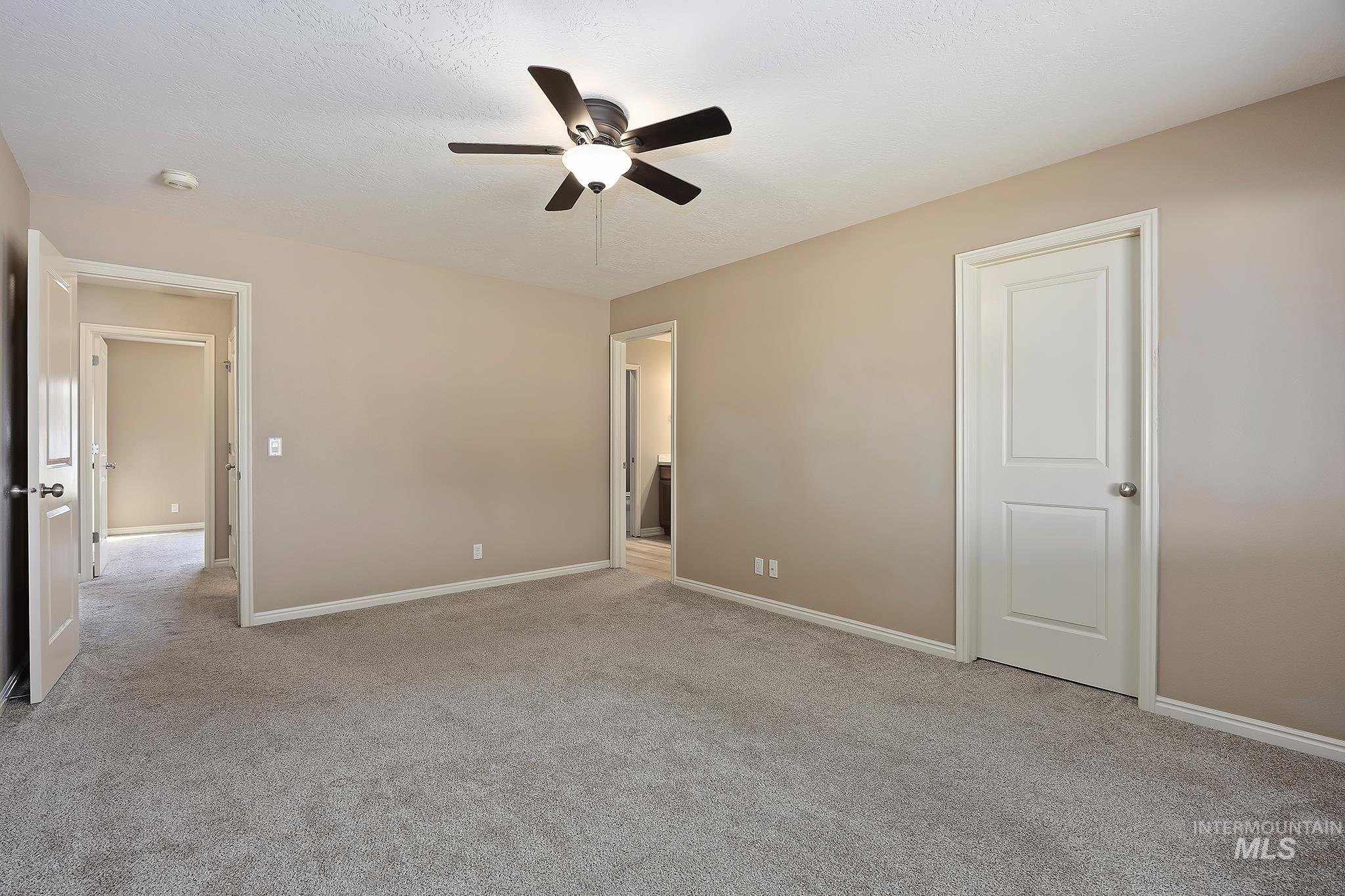 Unfurnished bedroom featuring light carpet and ceiling fan