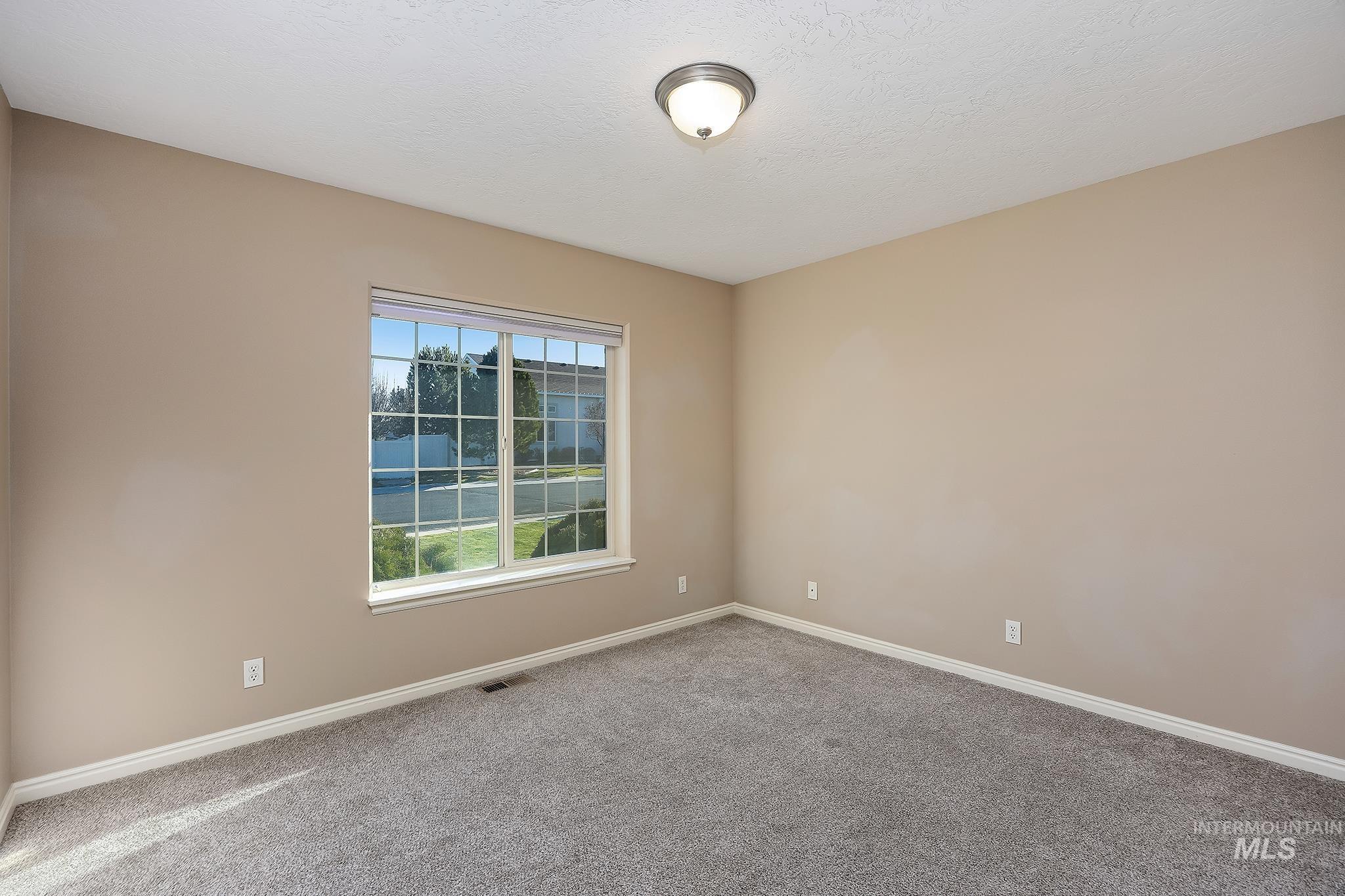 Empty room featuring carpet floors and a textured ceiling