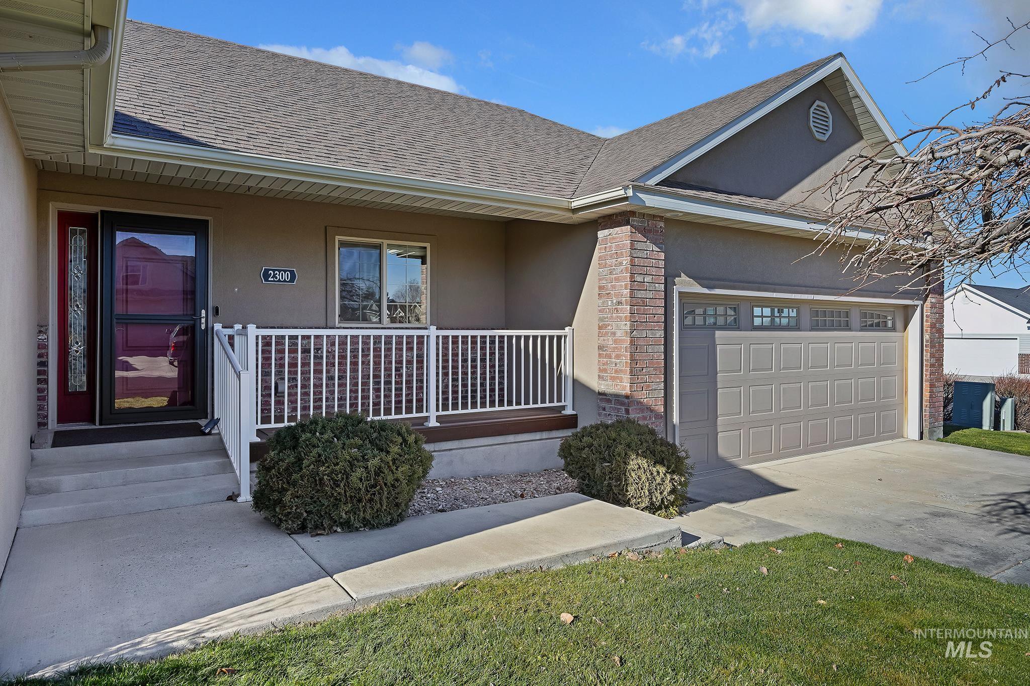 Doorway to property featuring stucco siding, roof with shingles, a porch, an attached garage, and driveway
