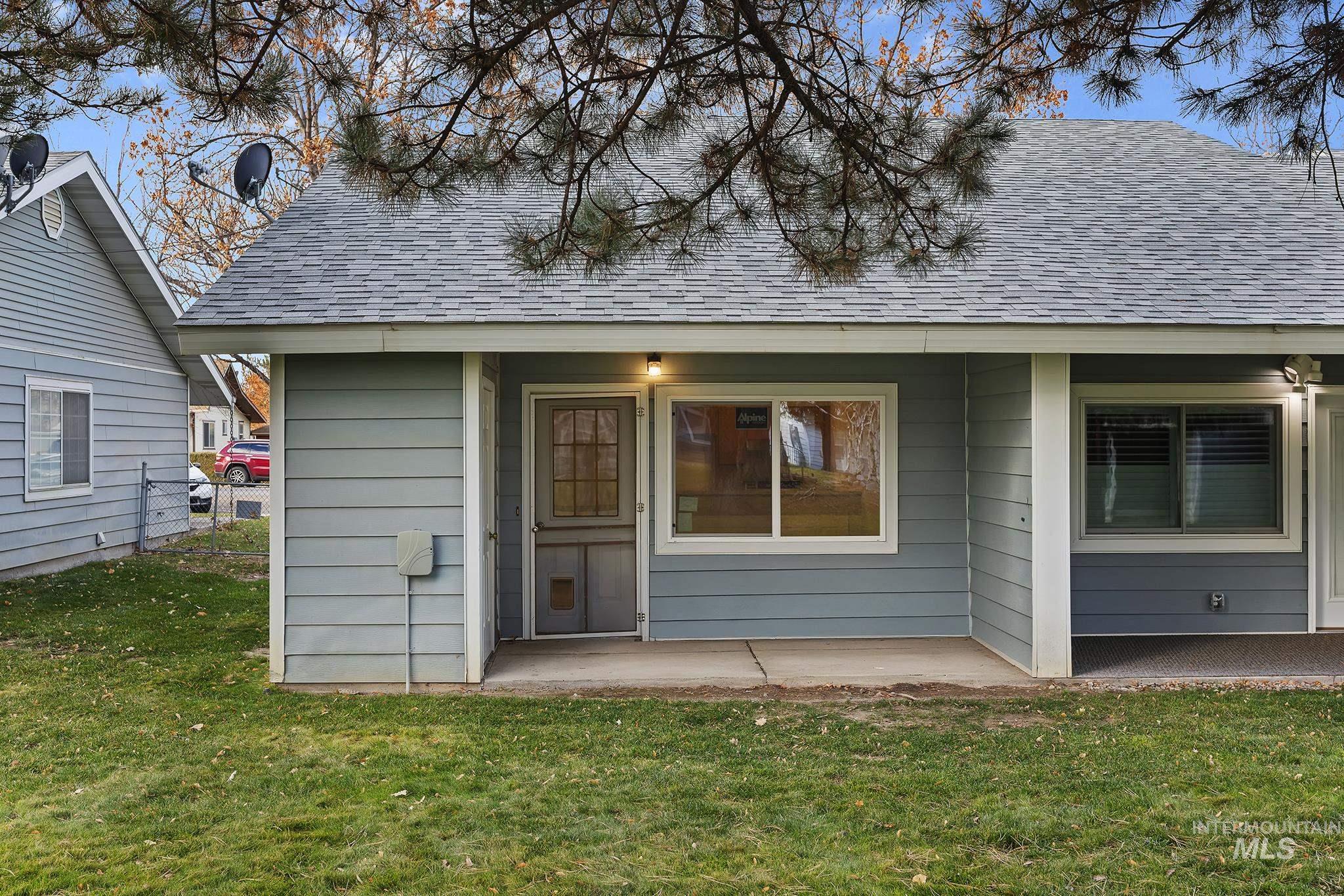 Rear view of property with a shingled roof and a lawn