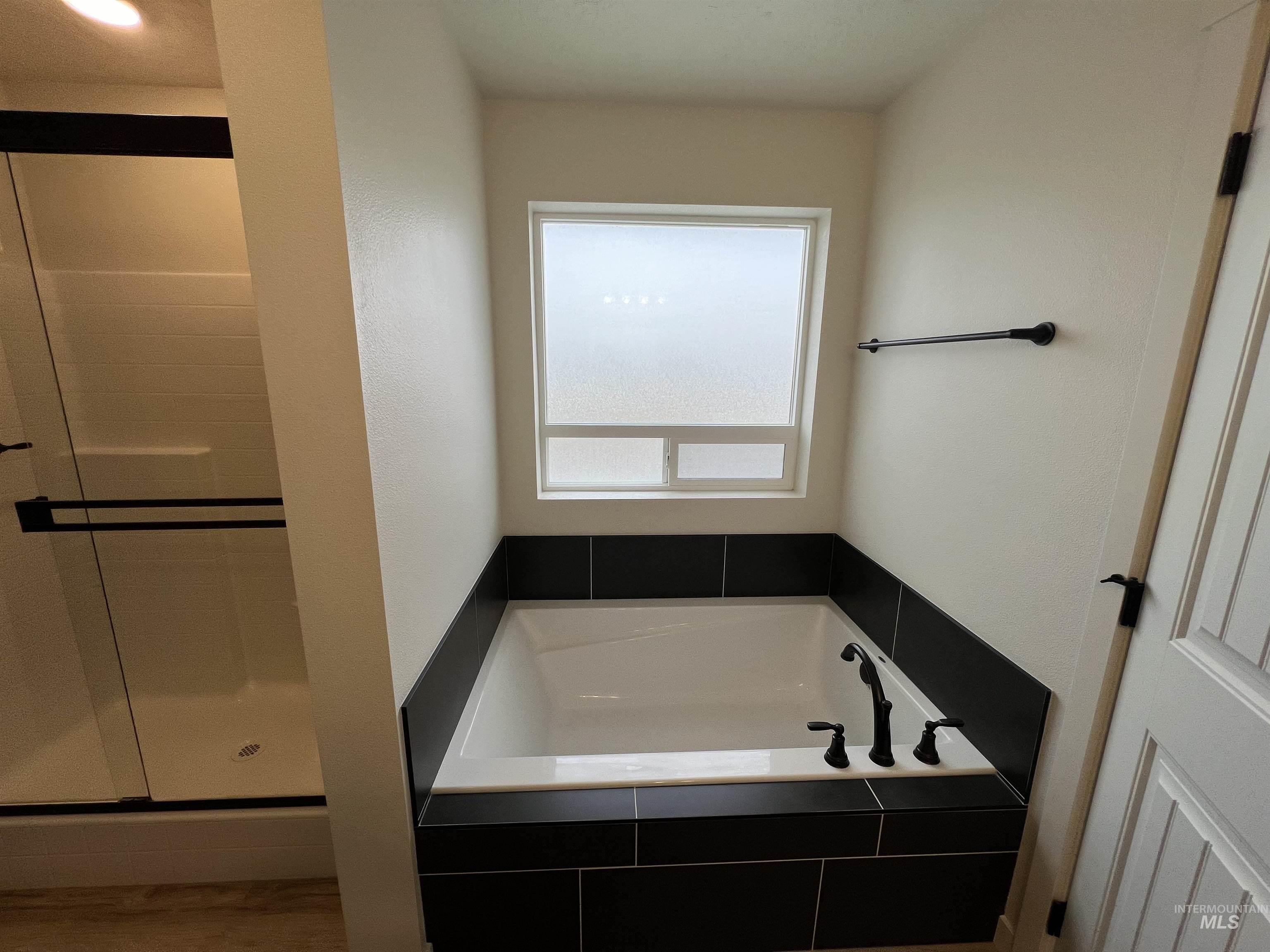 Bathroom with a bath and a shower stall