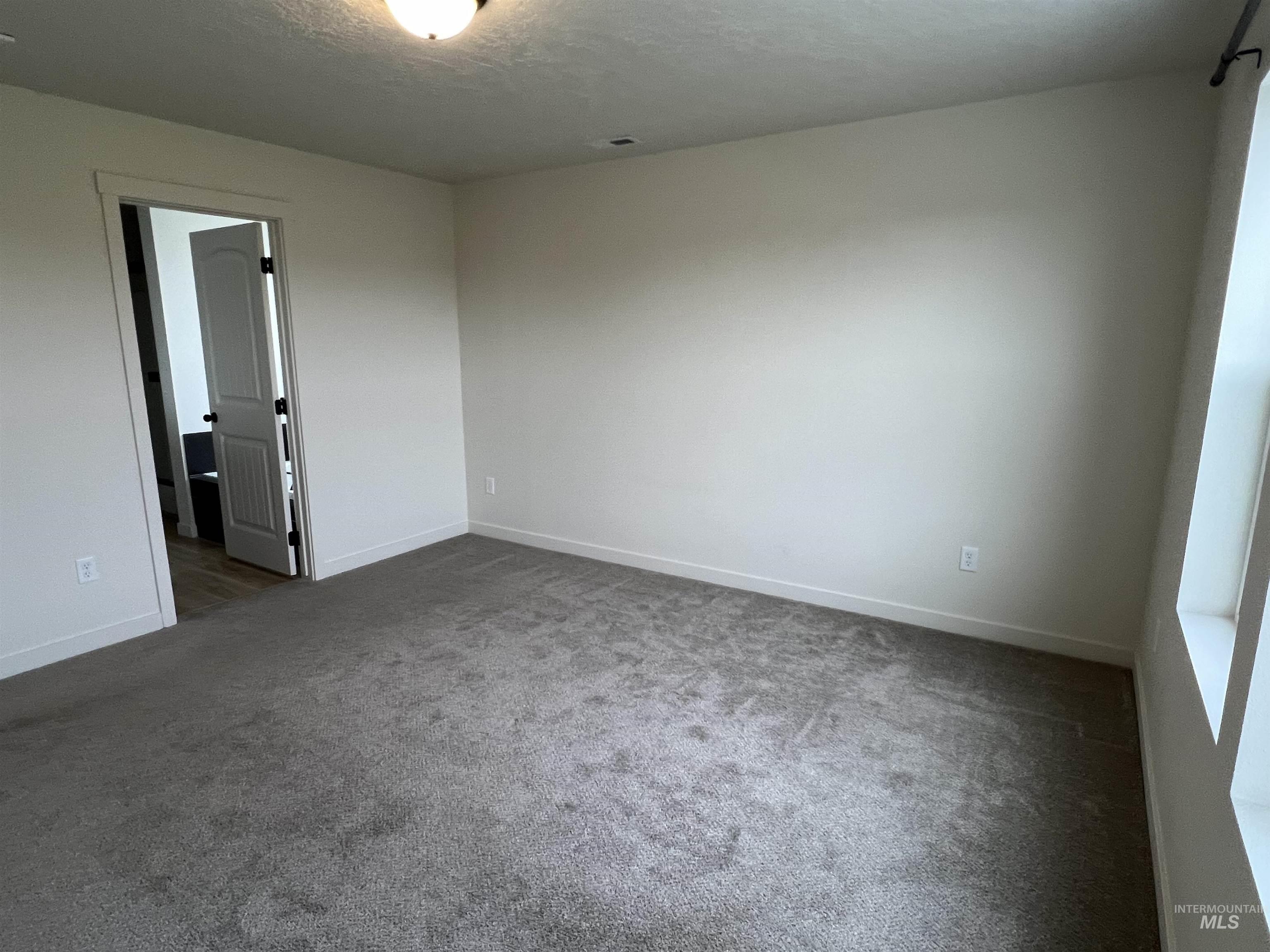 Spare room with carpet floors and a textured ceiling