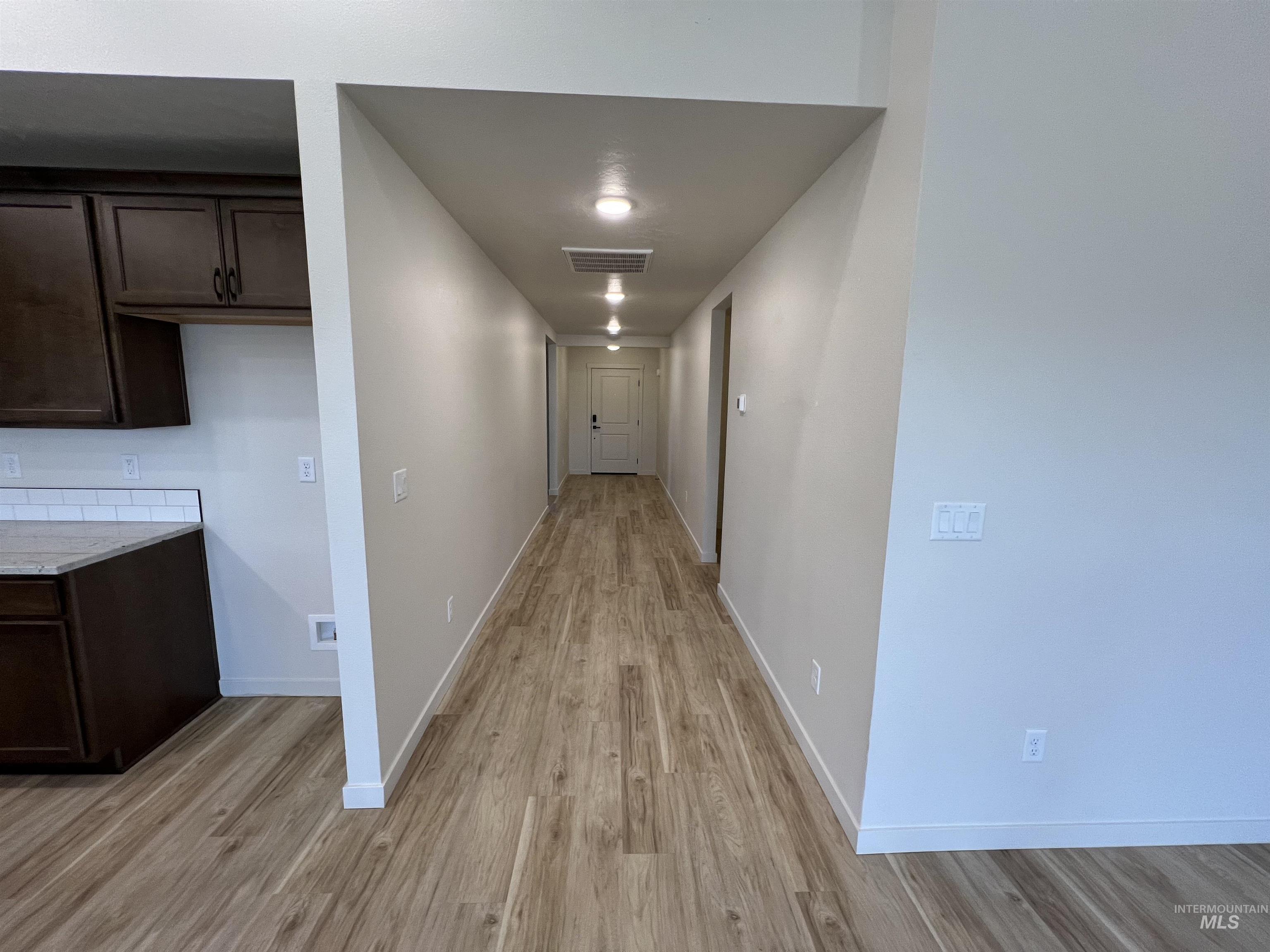 Hall with light wood-style floors and baseboards