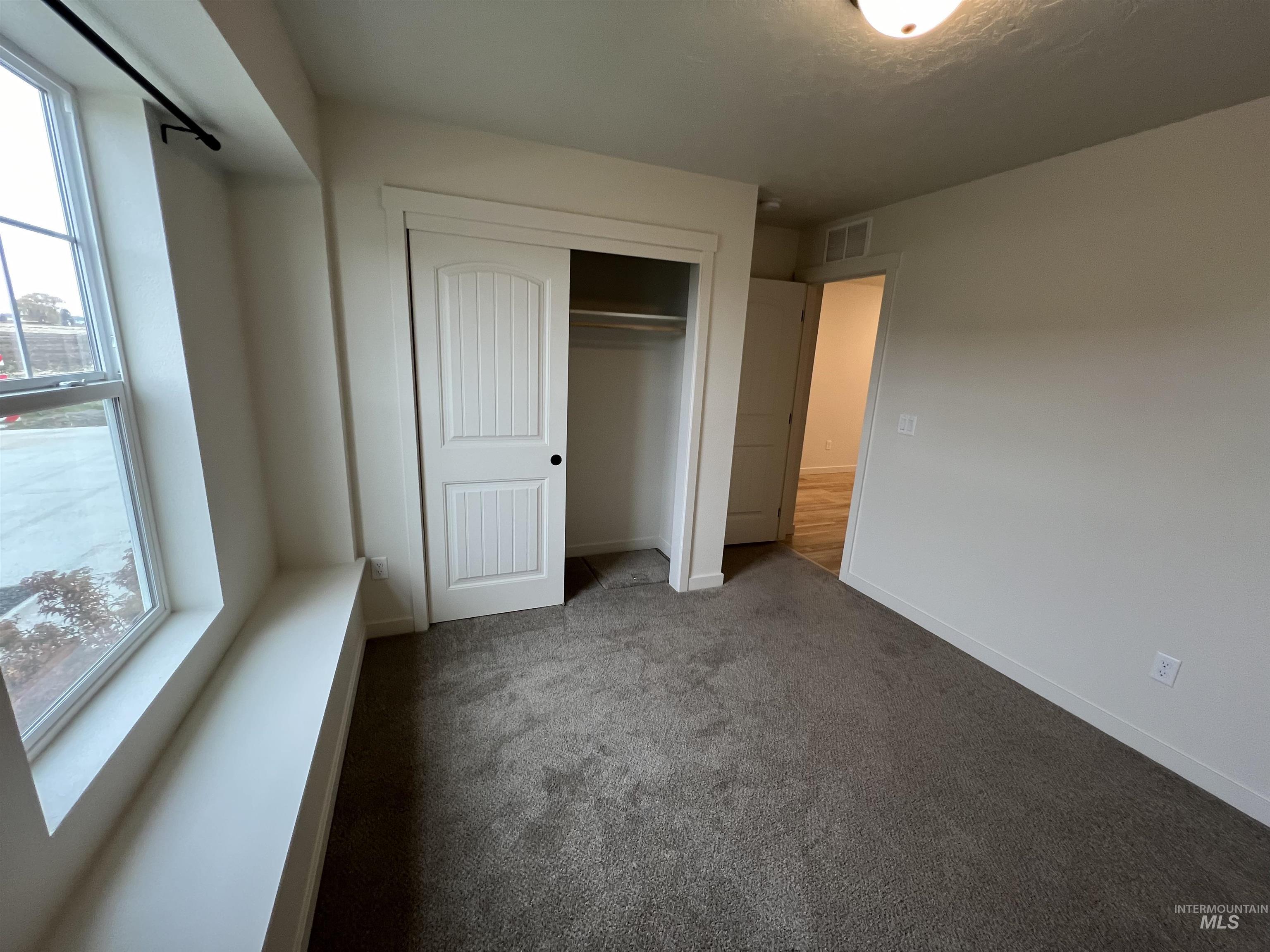 Unfurnished bedroom with carpet and a closet