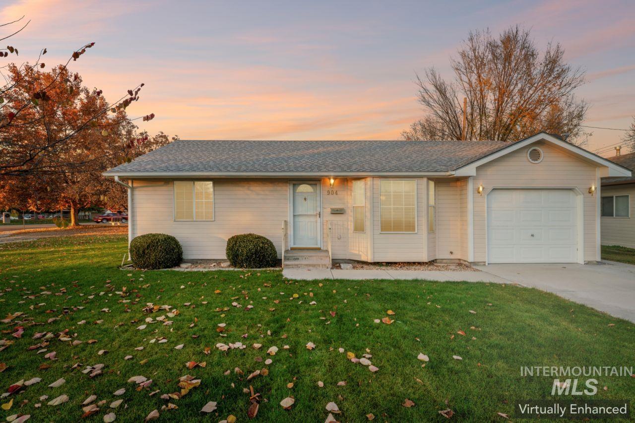 View of front of property featuring a front lawn, an attached garage, concrete driveway, and roof with shingles