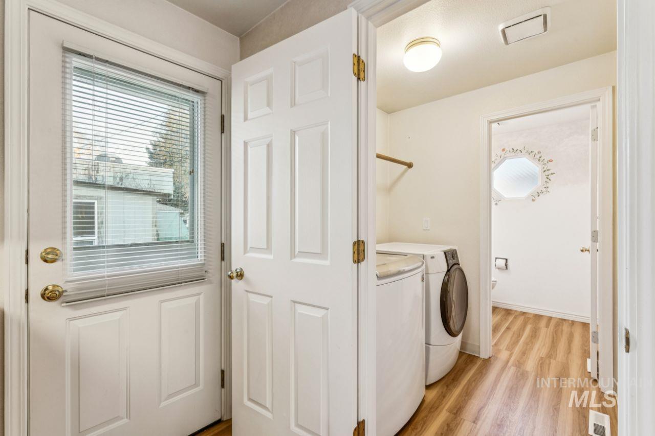 Laundry area with light wood-type flooring and washer and clothes dryer
