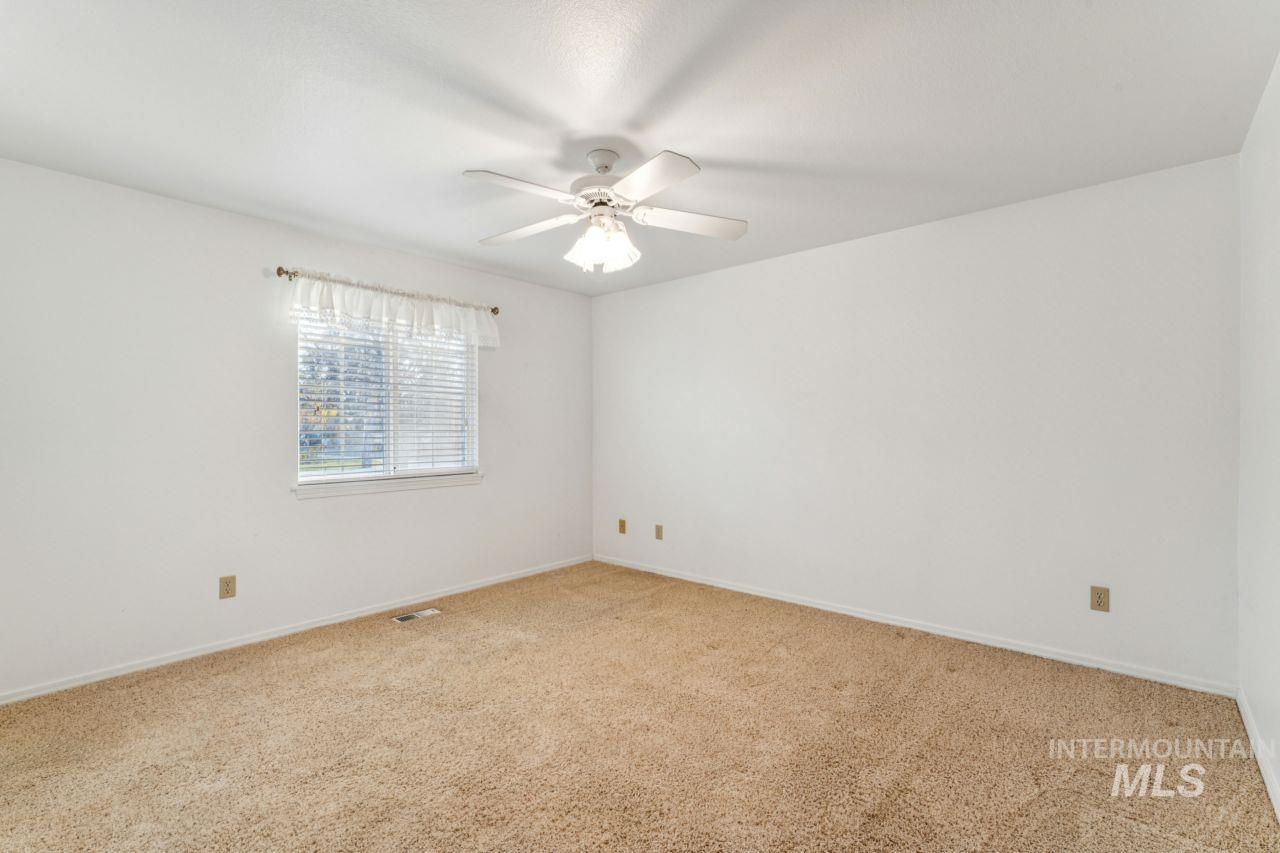 Unfurnished room featuring light colored carpet and a ceiling fan