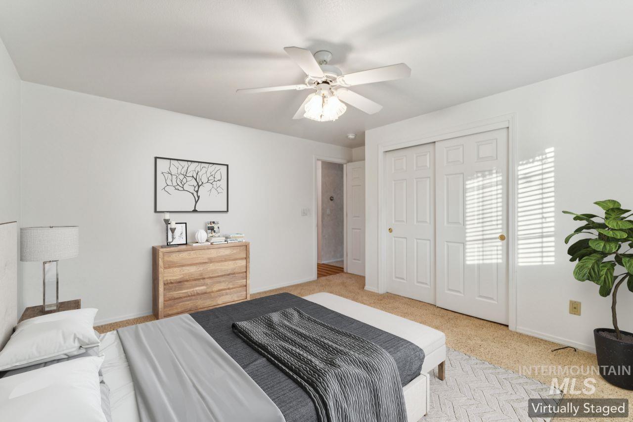 Carpeted bedroom featuring a ceiling fan and a closet
