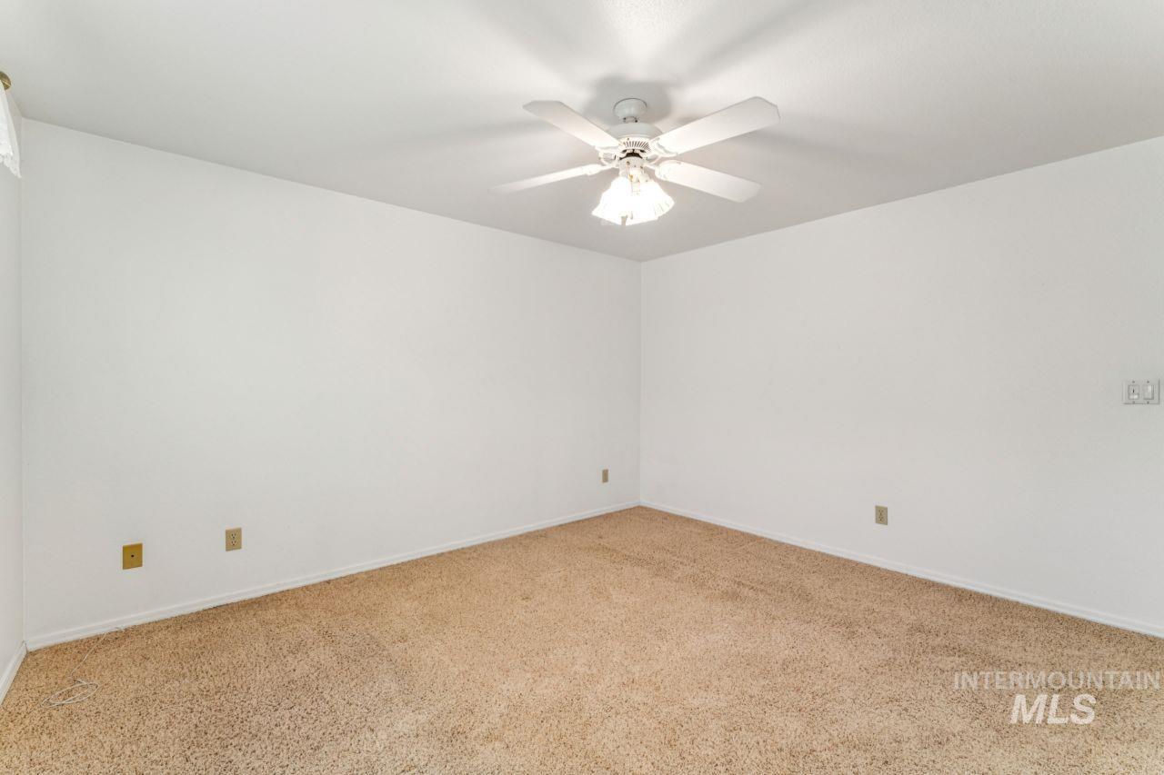 Spare room with carpet and a ceiling fan