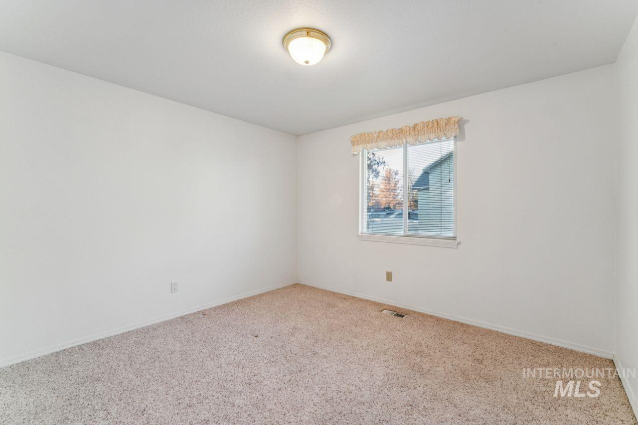 Carpeted empty room featuring baseboards