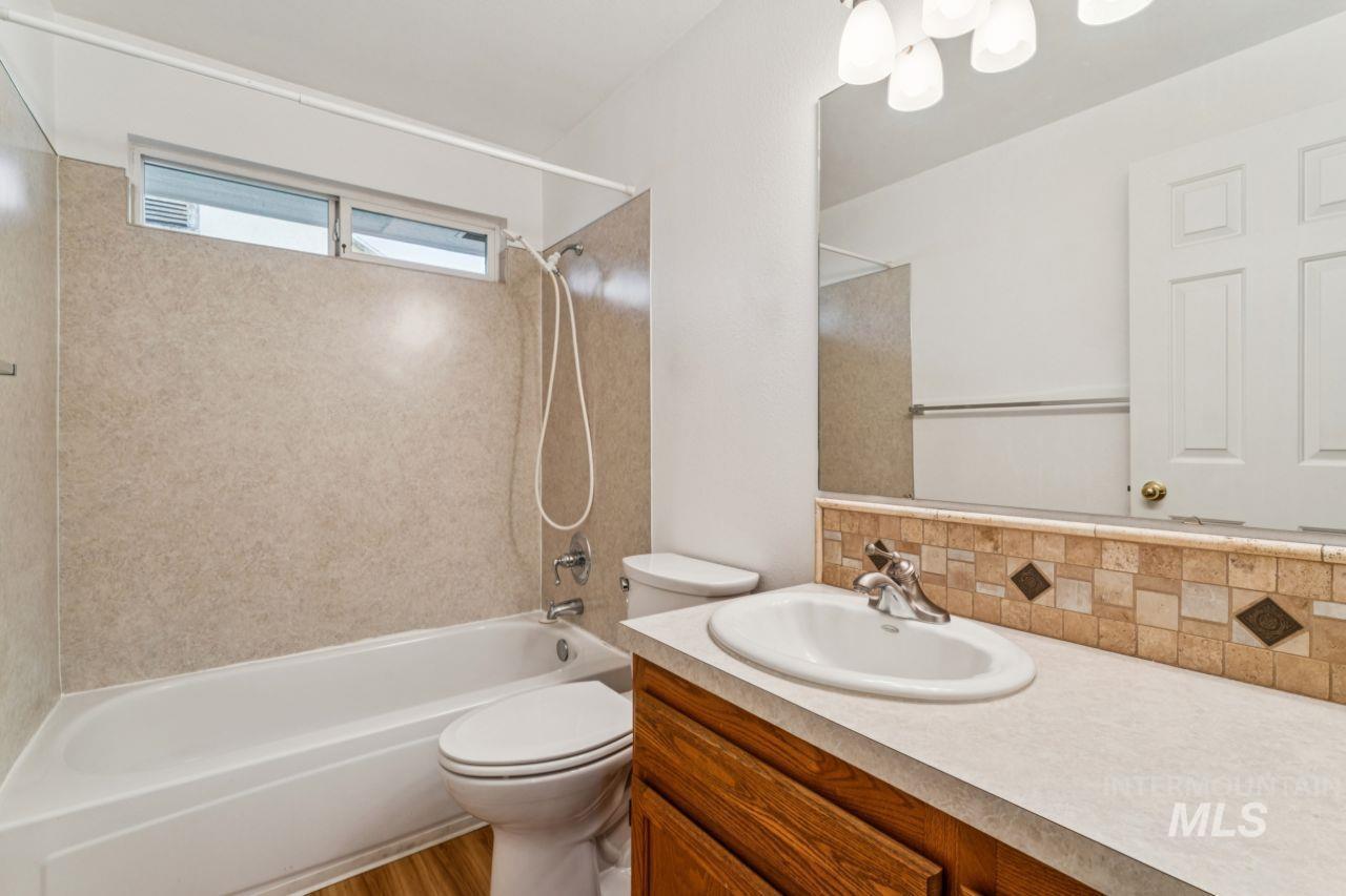Full bath featuring vanity,  shower combination, and decorative backsplash