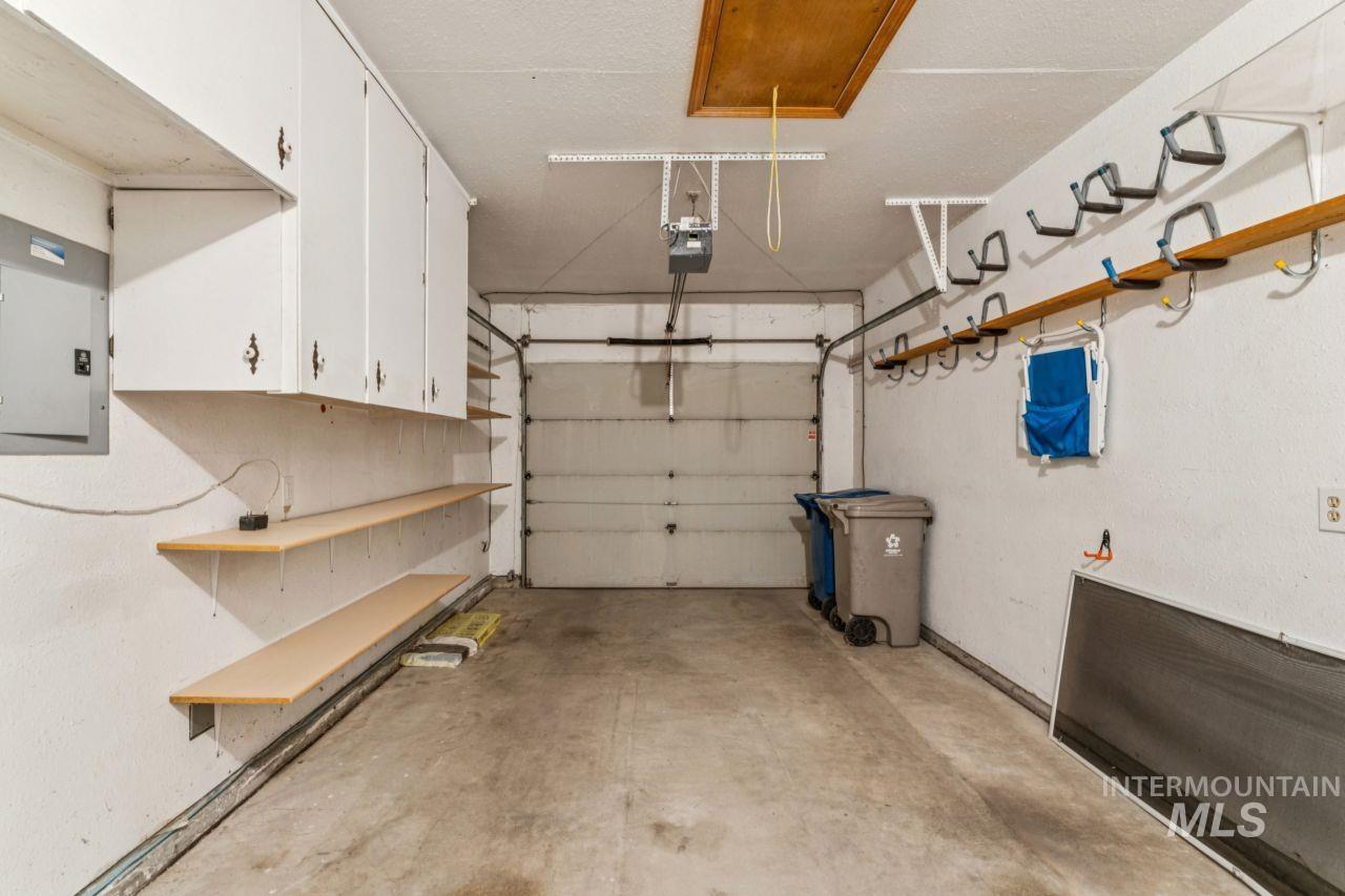 Garage featuring electric panel and a garage door opener