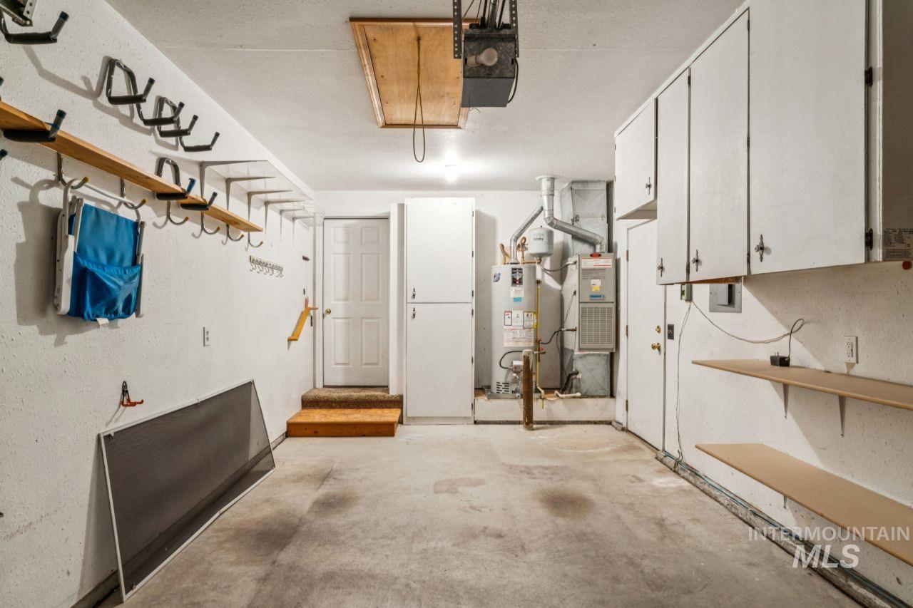 Garage featuring water heater and a garage door opener