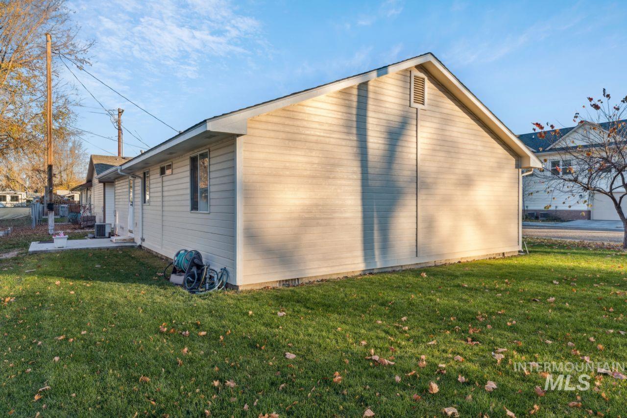 View of side of home featuring a yard and a central air condition unit