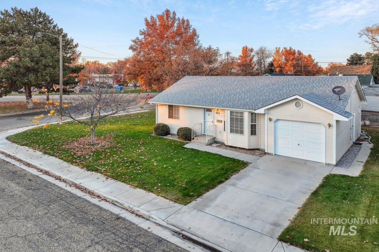 Ranch-style house featuring a front yard, roof with shingles, driveway, and a garage