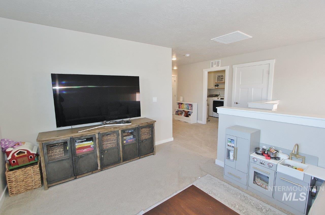 Living room featuring carpet and a textured ceiling