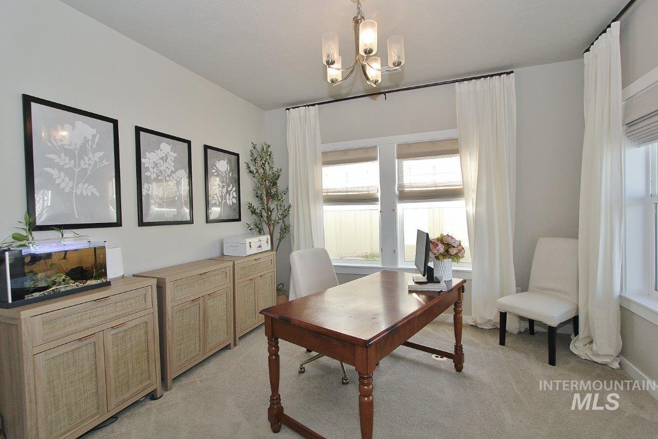 Office with light colored carpet and a chandelier