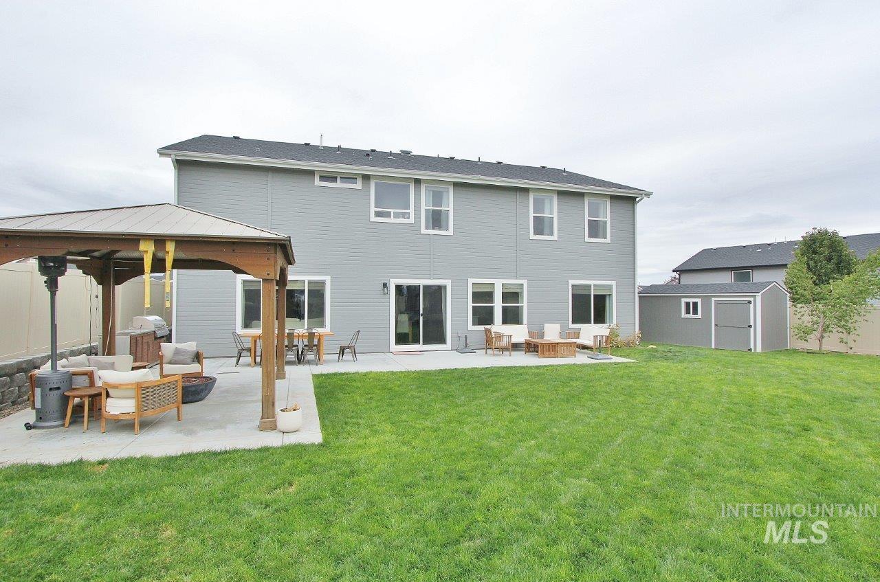 Rear view of house featuring an outdoor living space, a gazebo, a shed, and a patio