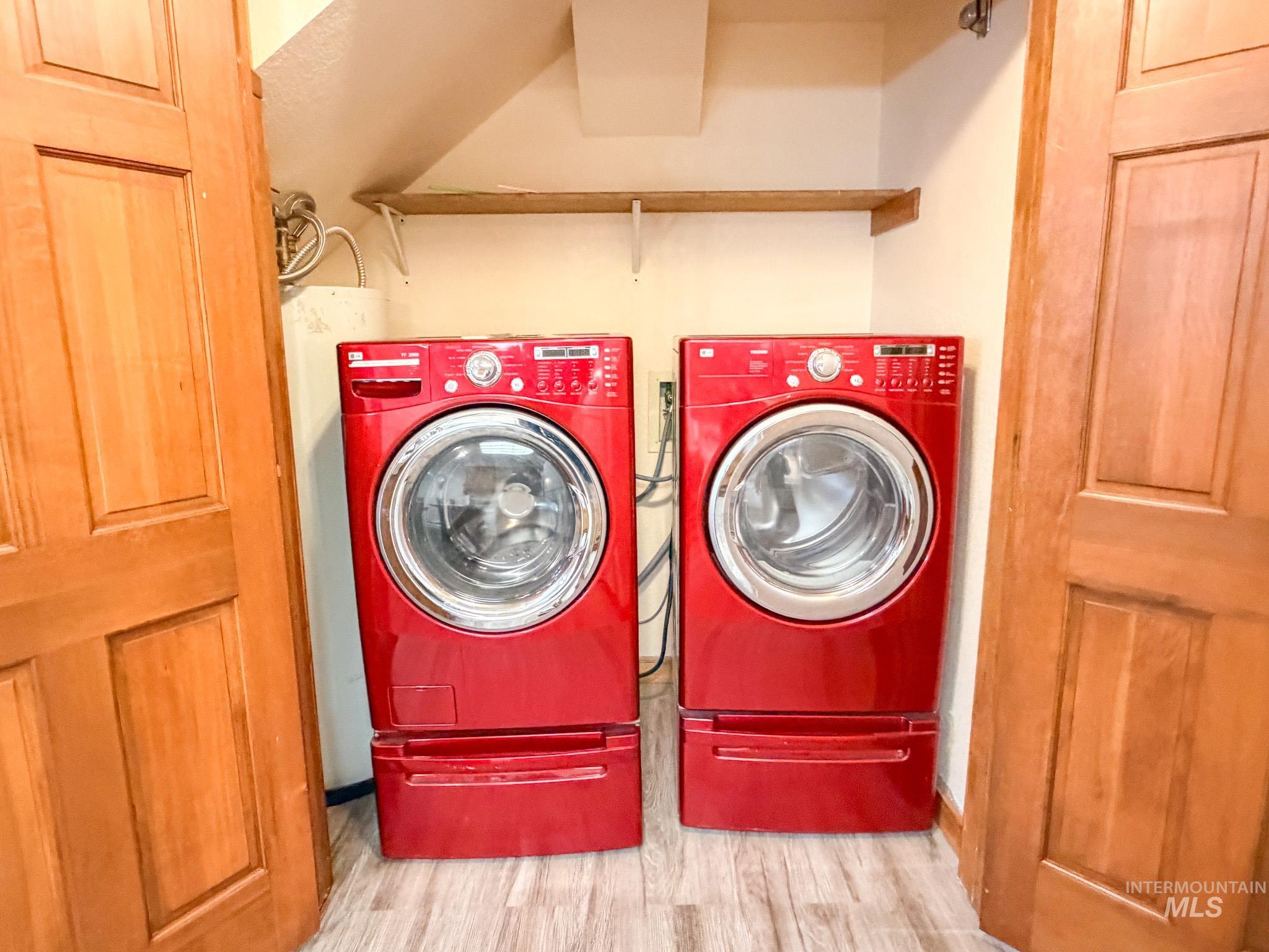Washroom featuring washer and dryer and wood finished floors