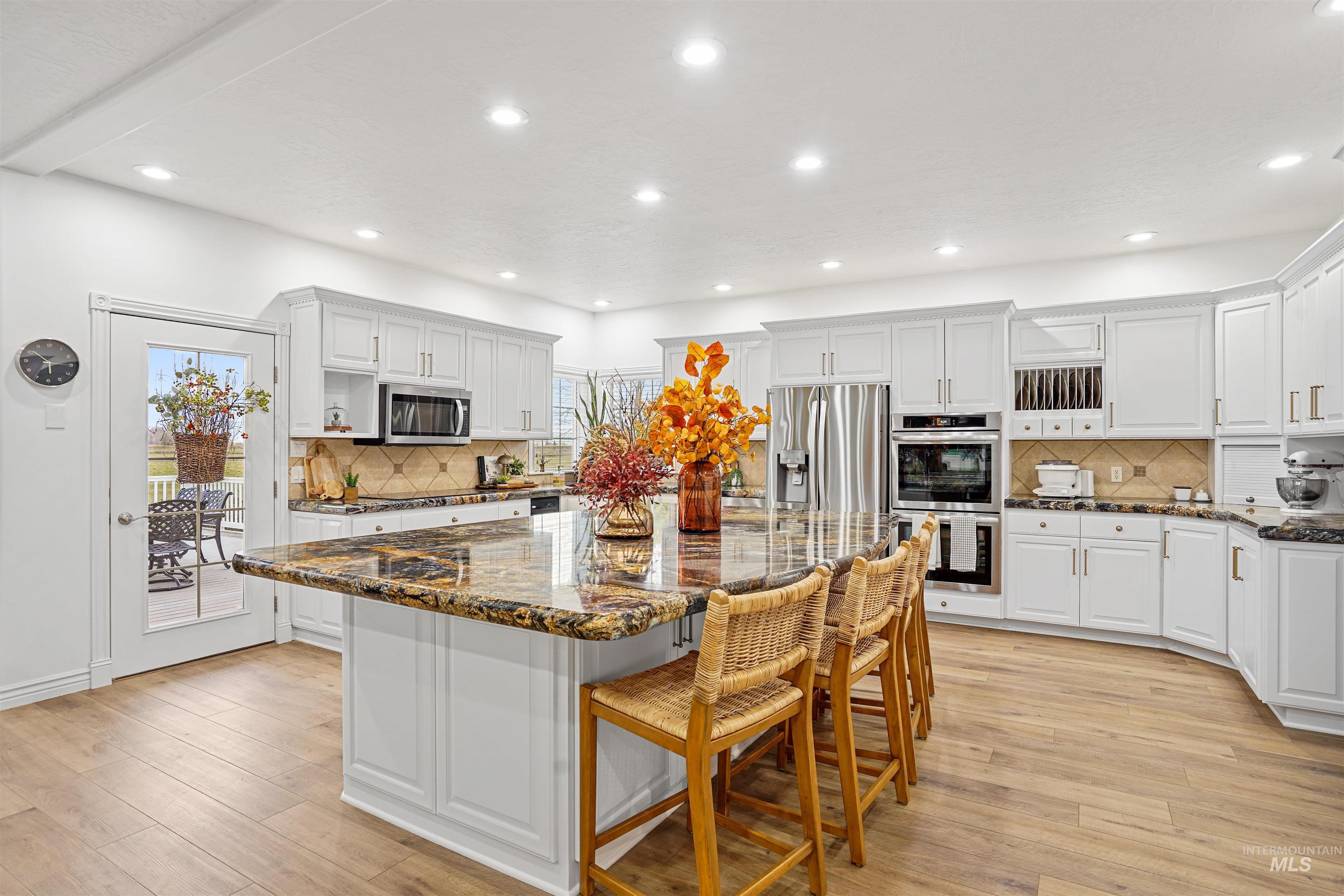 Kitchen with white cabinetry, tasteful backsplash, dark stone counters, and recessed lighting
