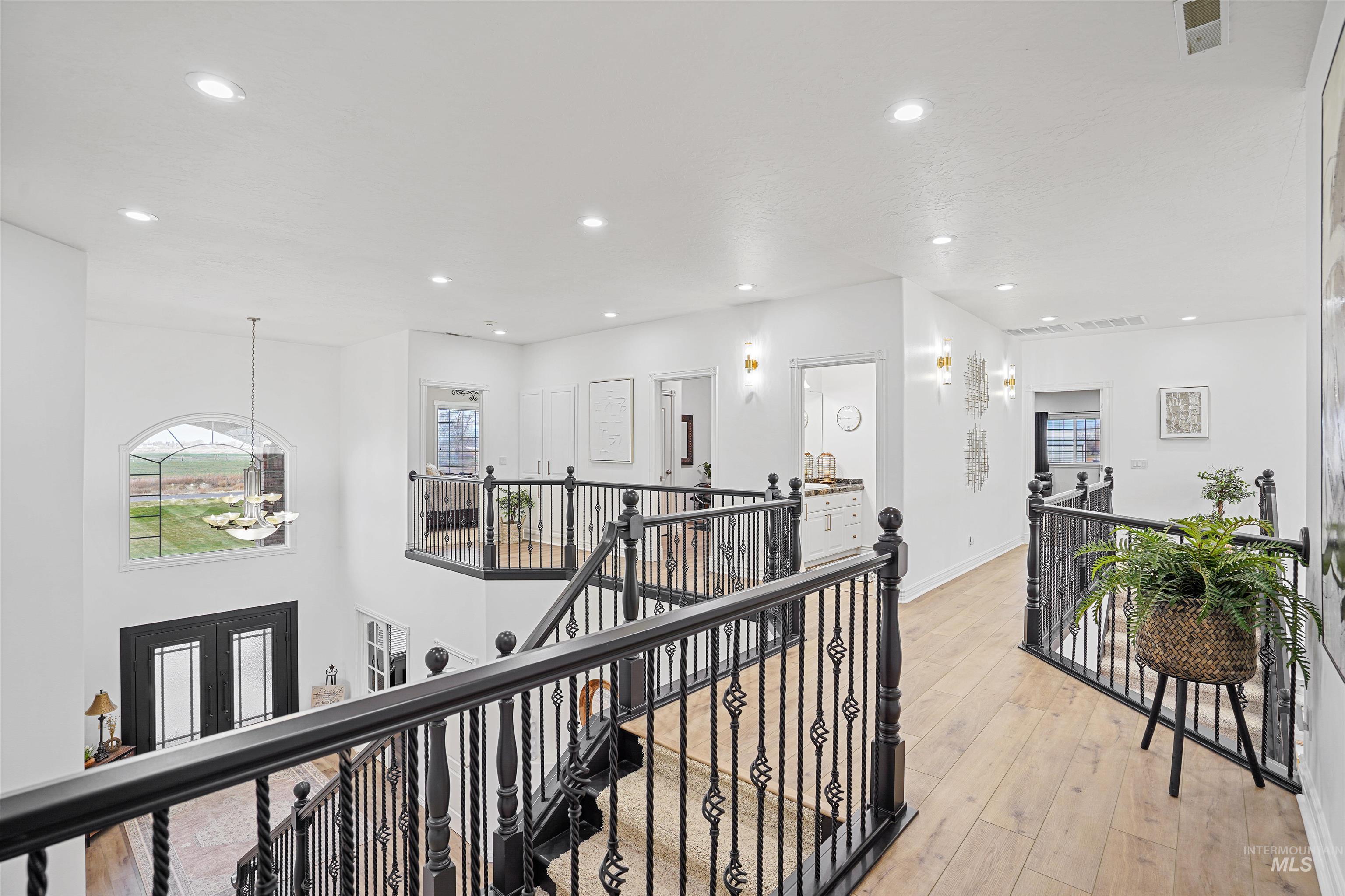 Hall featuring an upstairs landing, a chandelier, light wood-style floors, recessed lighting, and healthy amount of natural light