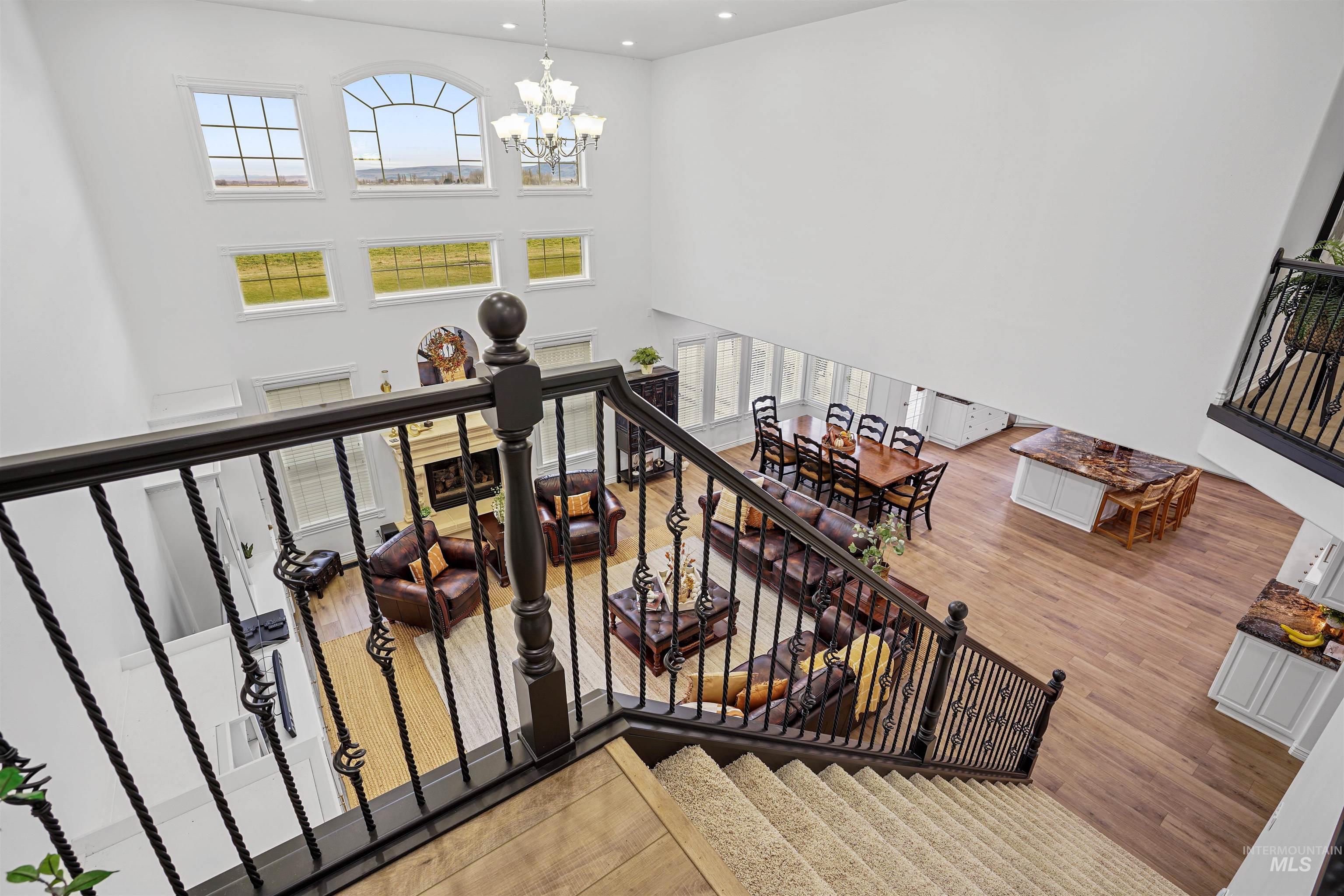 Staircase with a chandelier, plenty of natural light, hardwood / wood-style flooring, recessed lighting, and a high ceiling